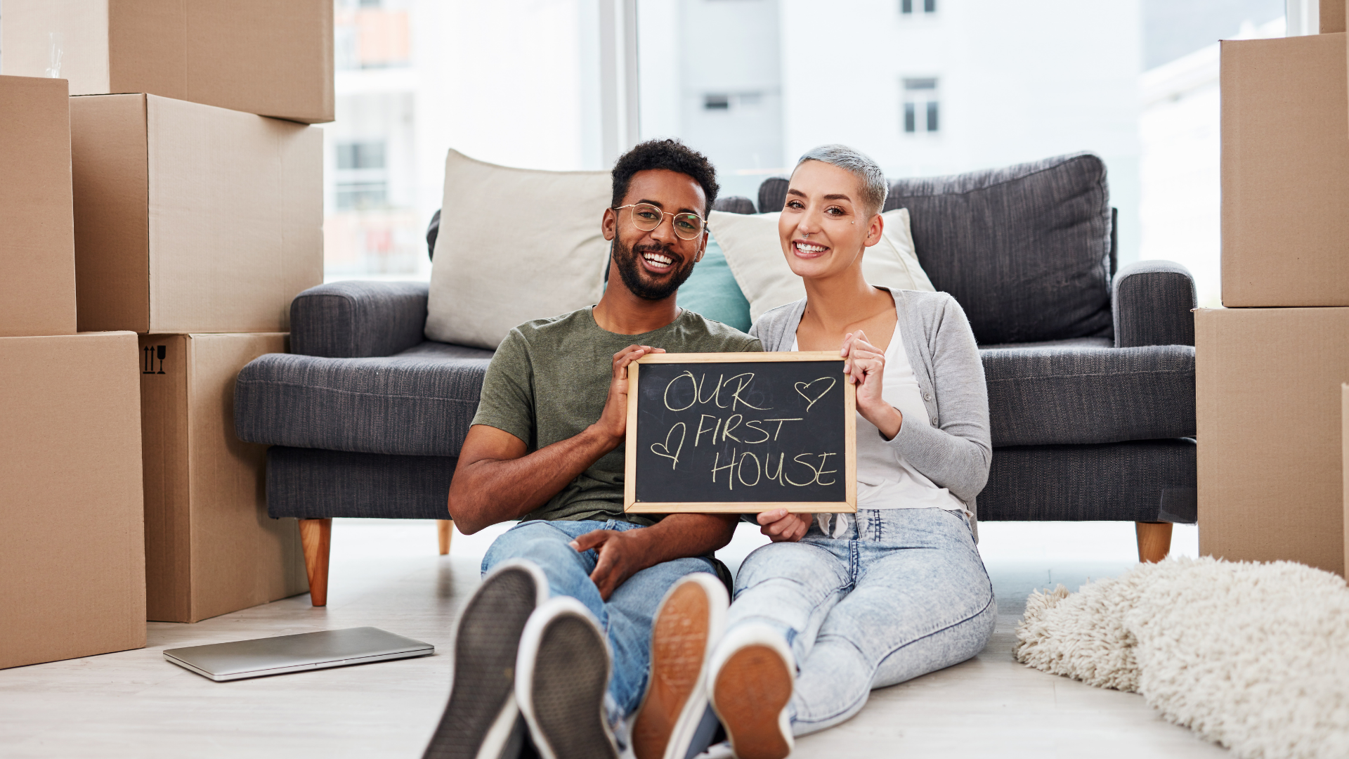 2 First time homebuyers sitting in their home among boxes